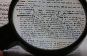  A magnifying glass over the definition of democracy in a dictionary.