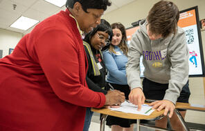 Students and educator work on an assignment