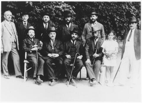 Group photo of men in suits and a young girl