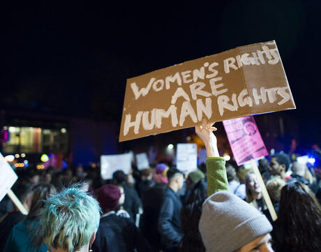 Image of protestor holding a sign with "Women's Rights are Human Rights" written on it